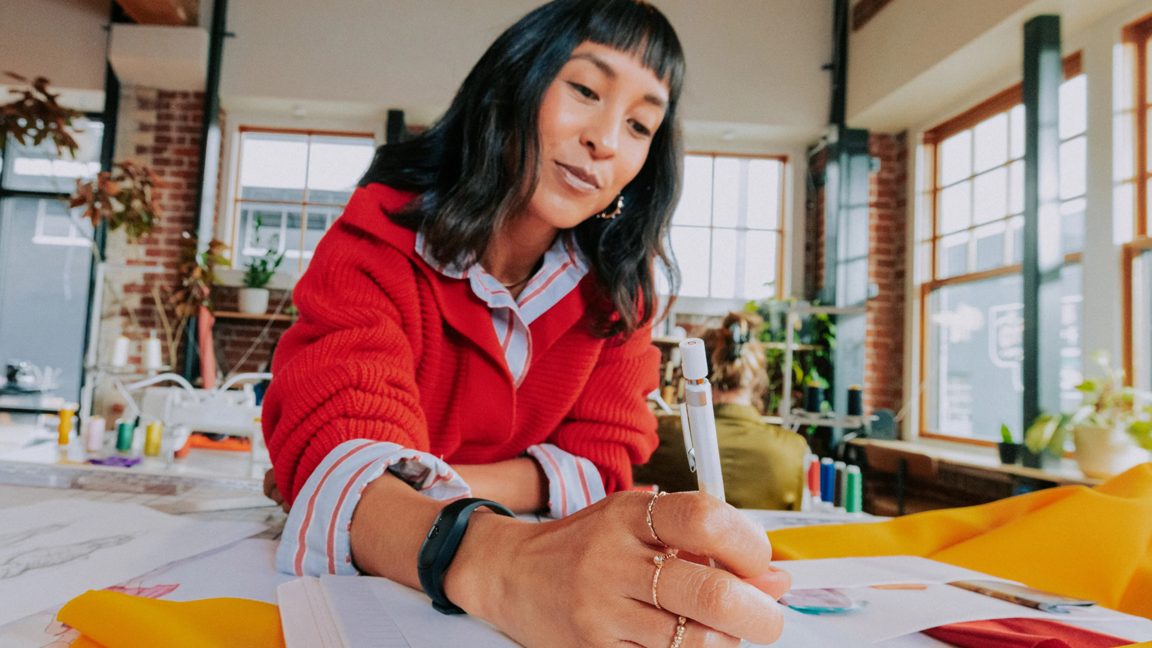 Woman drawing at a table wearing the Bee wristband